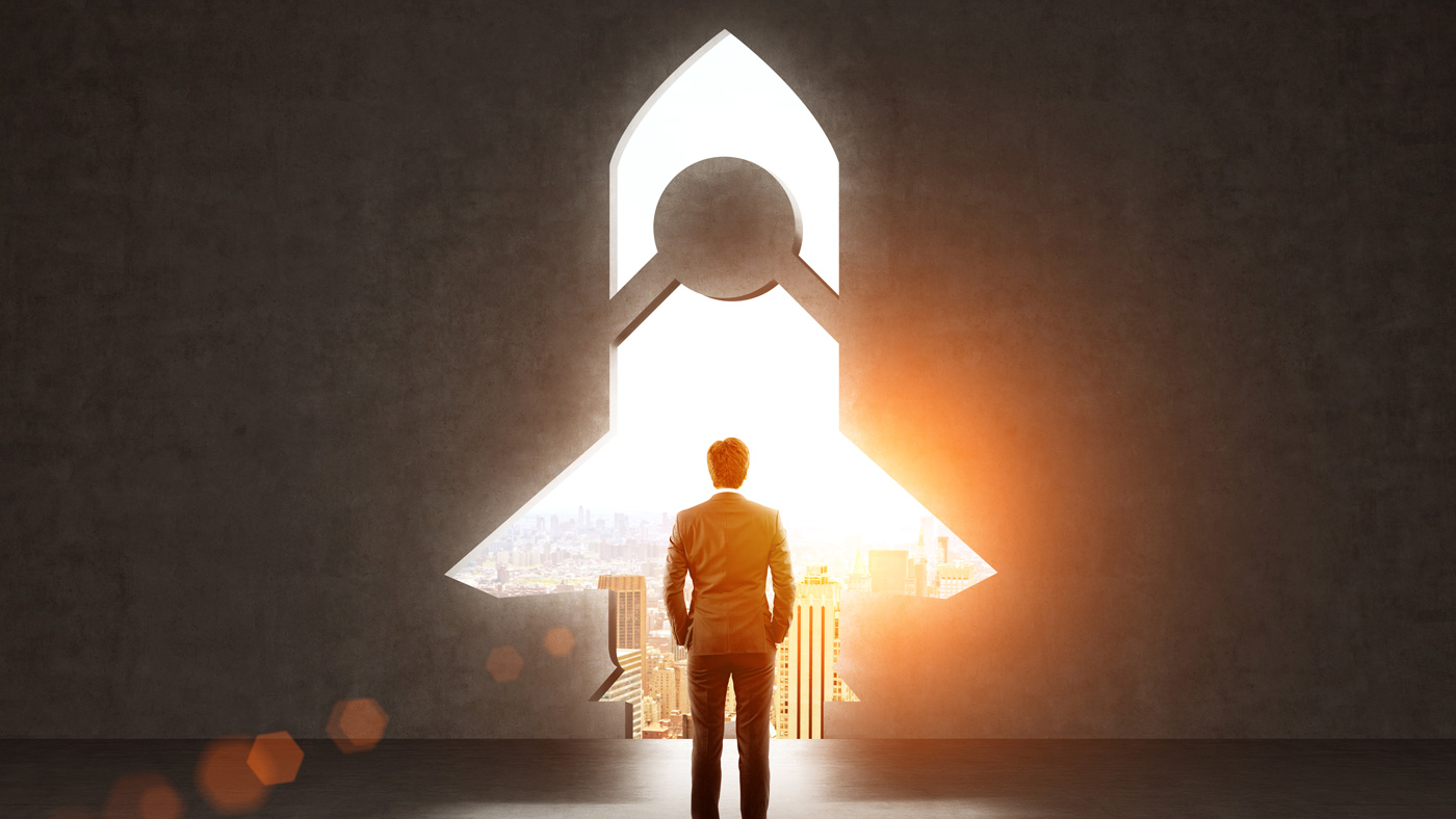 Startup rocket shaped gap Start up concept with businessman standing in front of rocket shaped gap in wall, revealing sunlit New York city view New Business Stock Photo